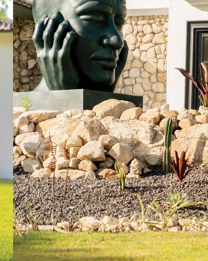 A large bronze face sculpture in the gardens